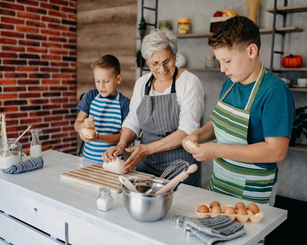 Grandmother cooking with her kids