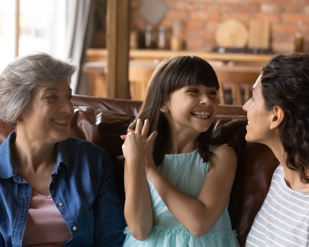 Mother, daughter, and grandmother talking together smiling